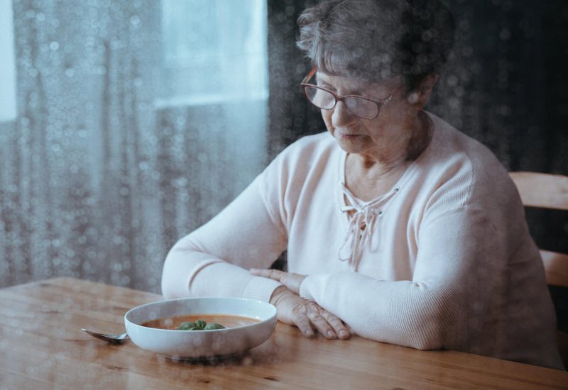 Sad, senior woman having lack of appetite