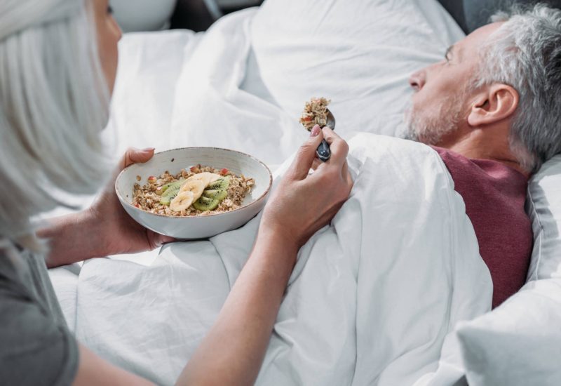 woman taking care of sick husband in bed at home